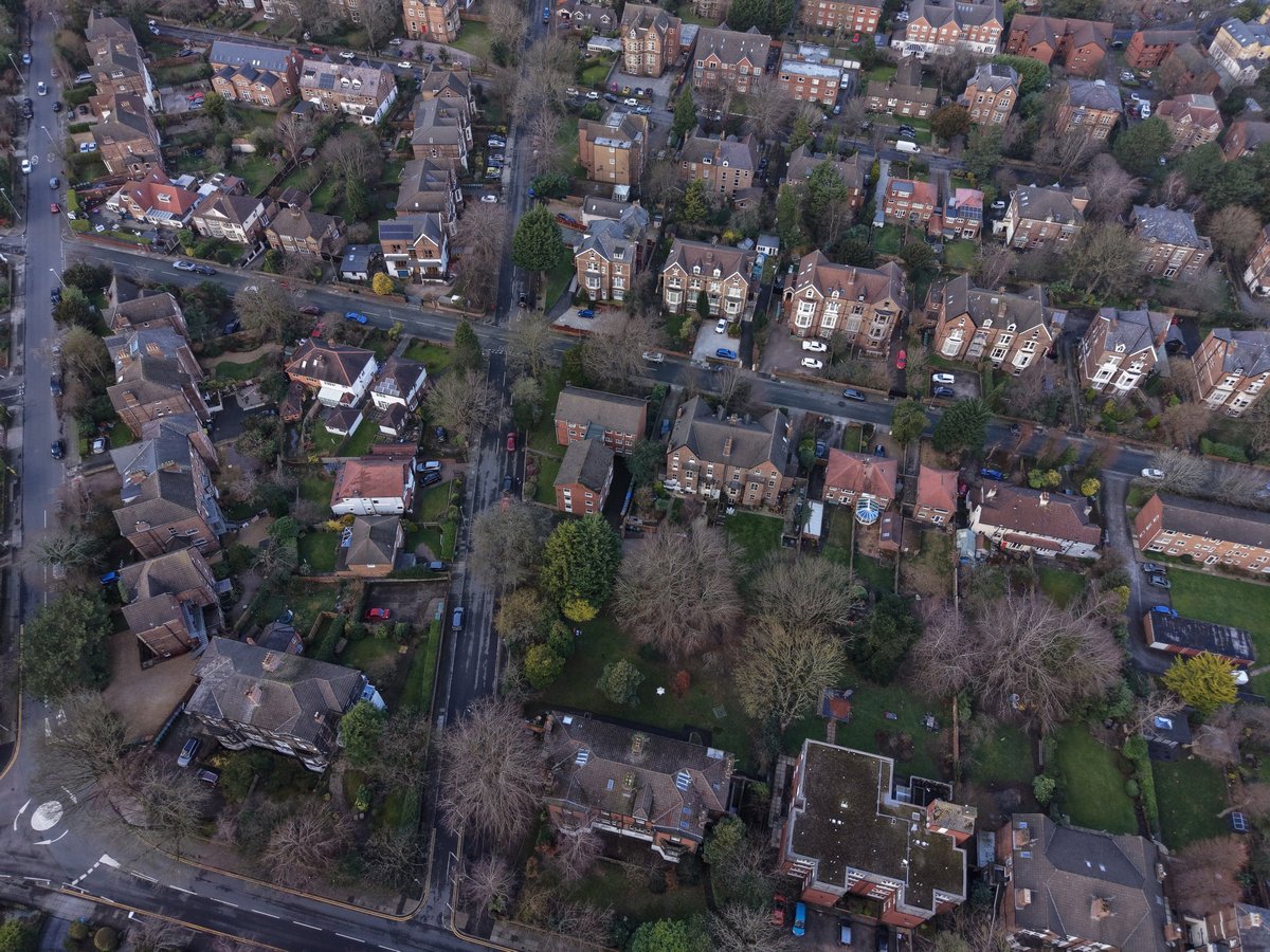 Aerial view across the rooftops and gardens of a UK town
