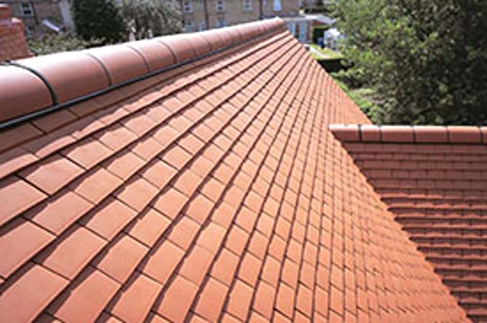 Red clay tile roof finished to a tidy grid pattern with matching ridge tiles